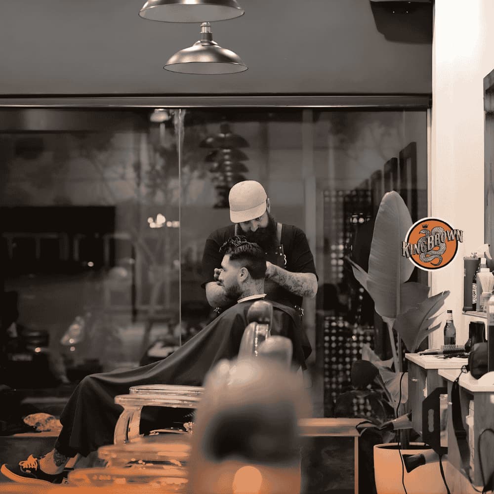 barber using king brown on his client